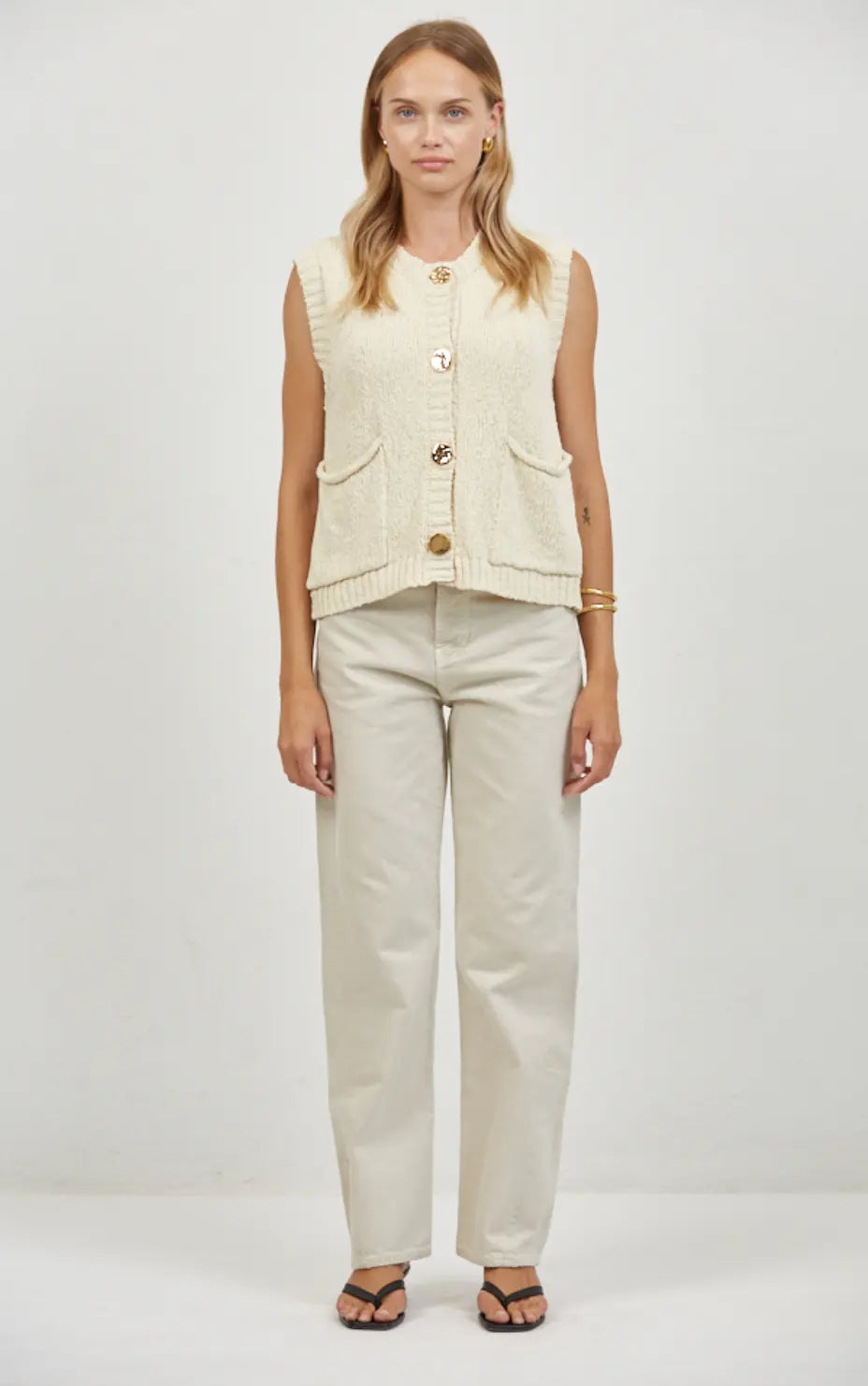 A.ren Marais buttoned knit vest in extra small, featuring a cozy knit fabric with button details, worn layered over a shirt.