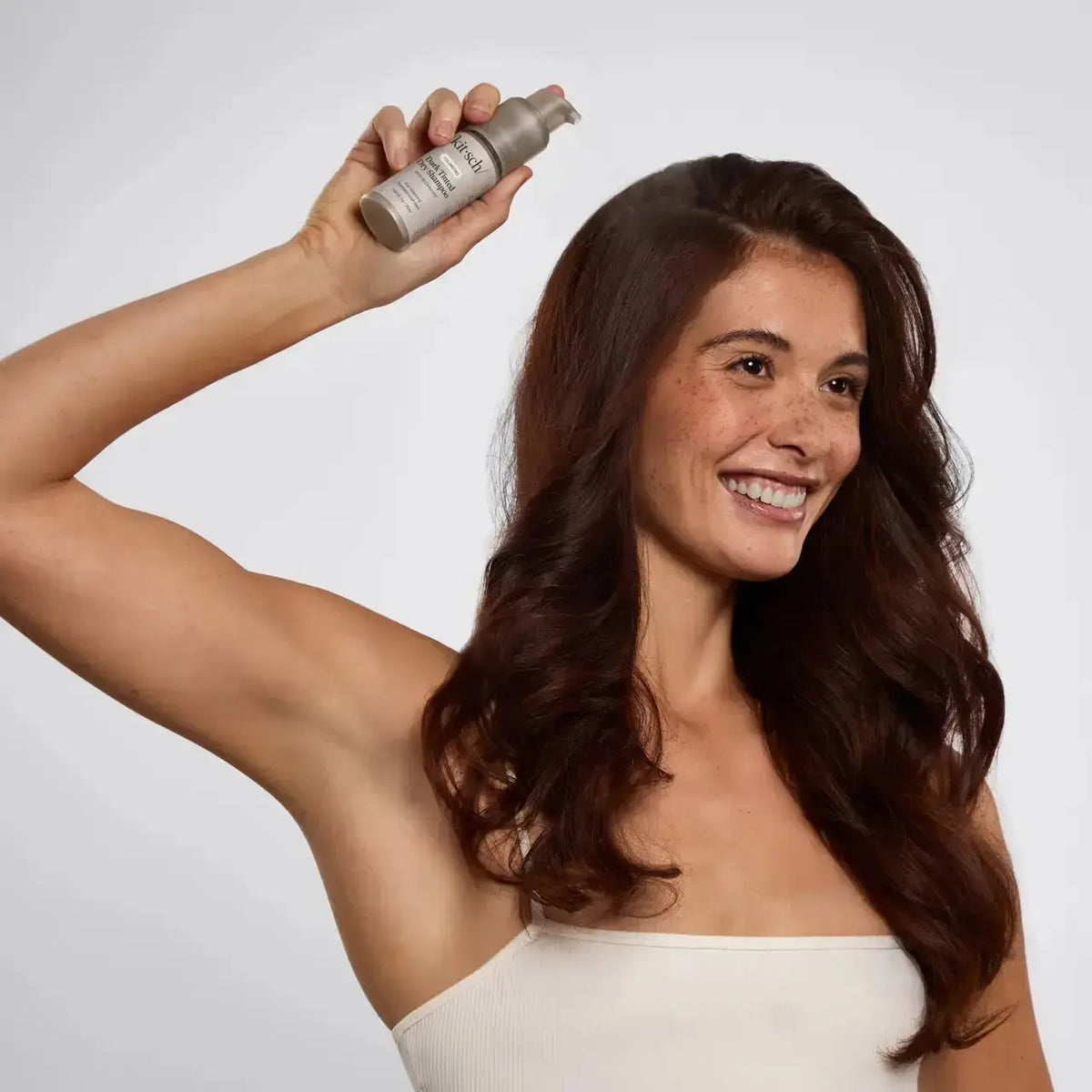 Kitsch Brown Tinted Dry Shampoo for hair, with a brown tint to refresh and absorb oil, in a sleek bottle.