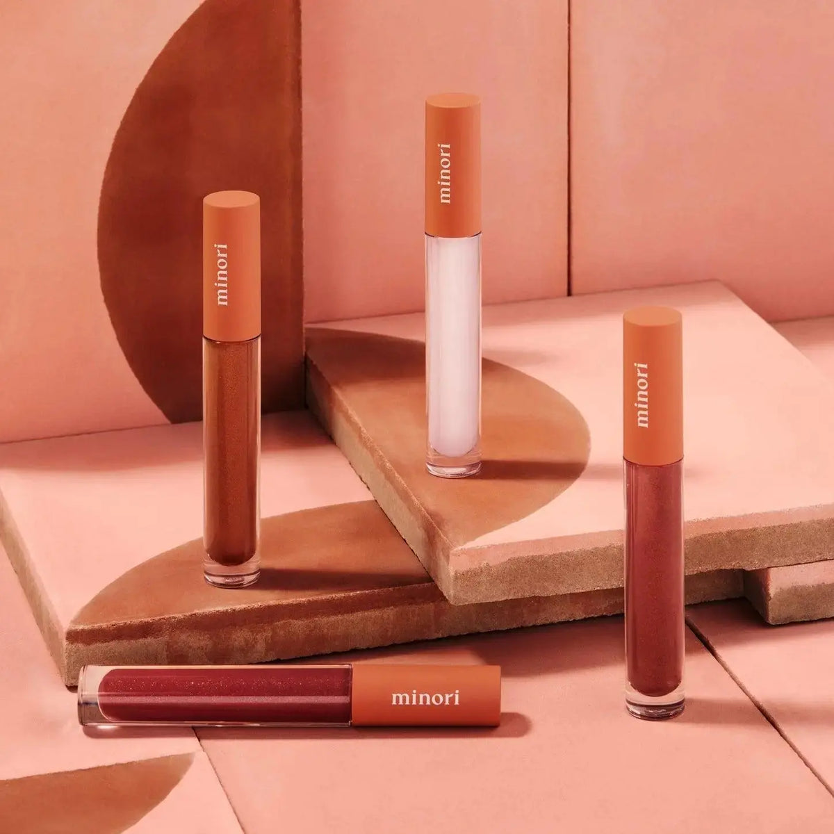 Minori Ultra-Hydrating Vegan Lip Gloss in a clear tube, showcasing a glossy, natural finish on smooth lips.