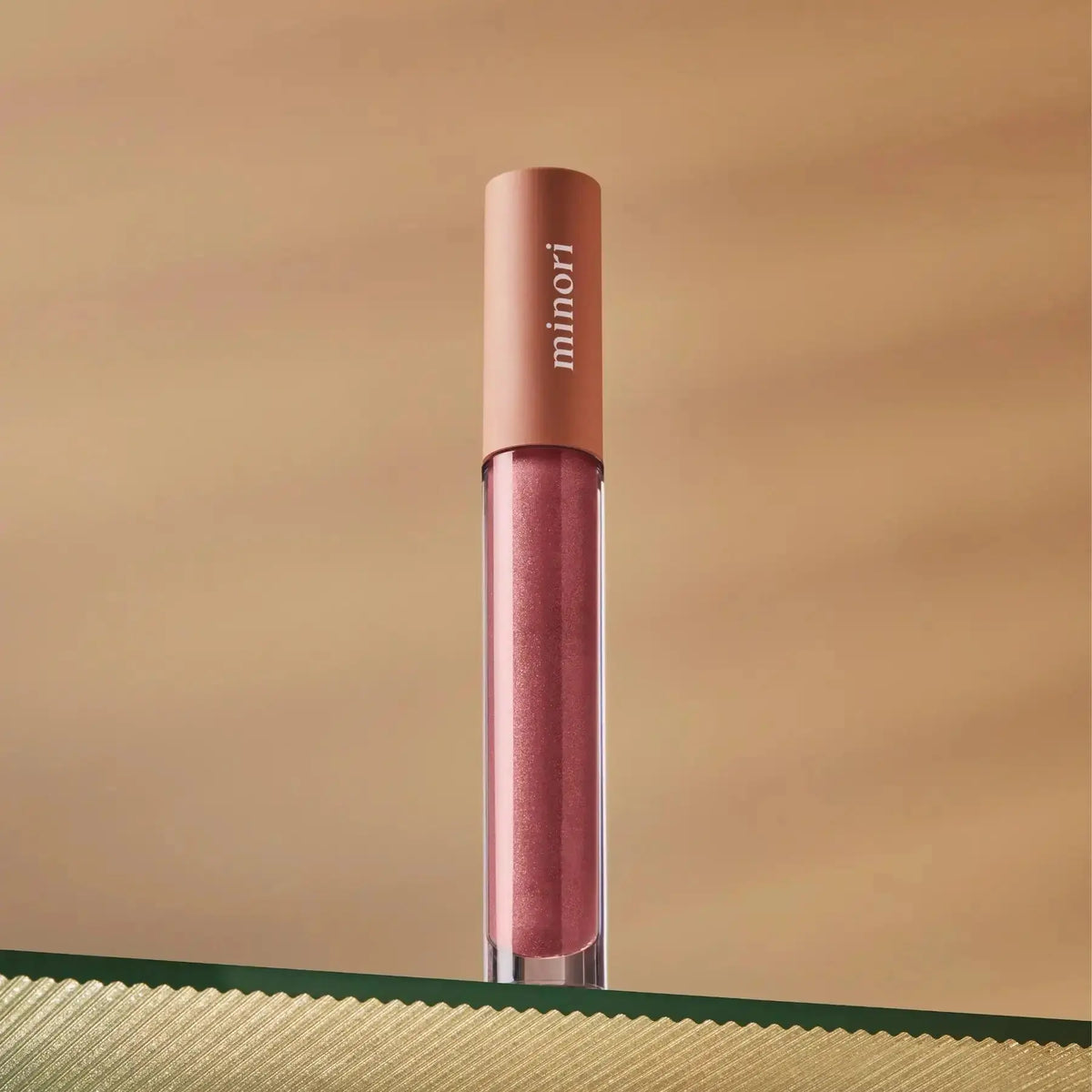 Minori Ultra-Hydrating Vegan Lip Gloss in a clear tube with a glossy finish, featuring a doe-foot applicator for smooth makeup application.