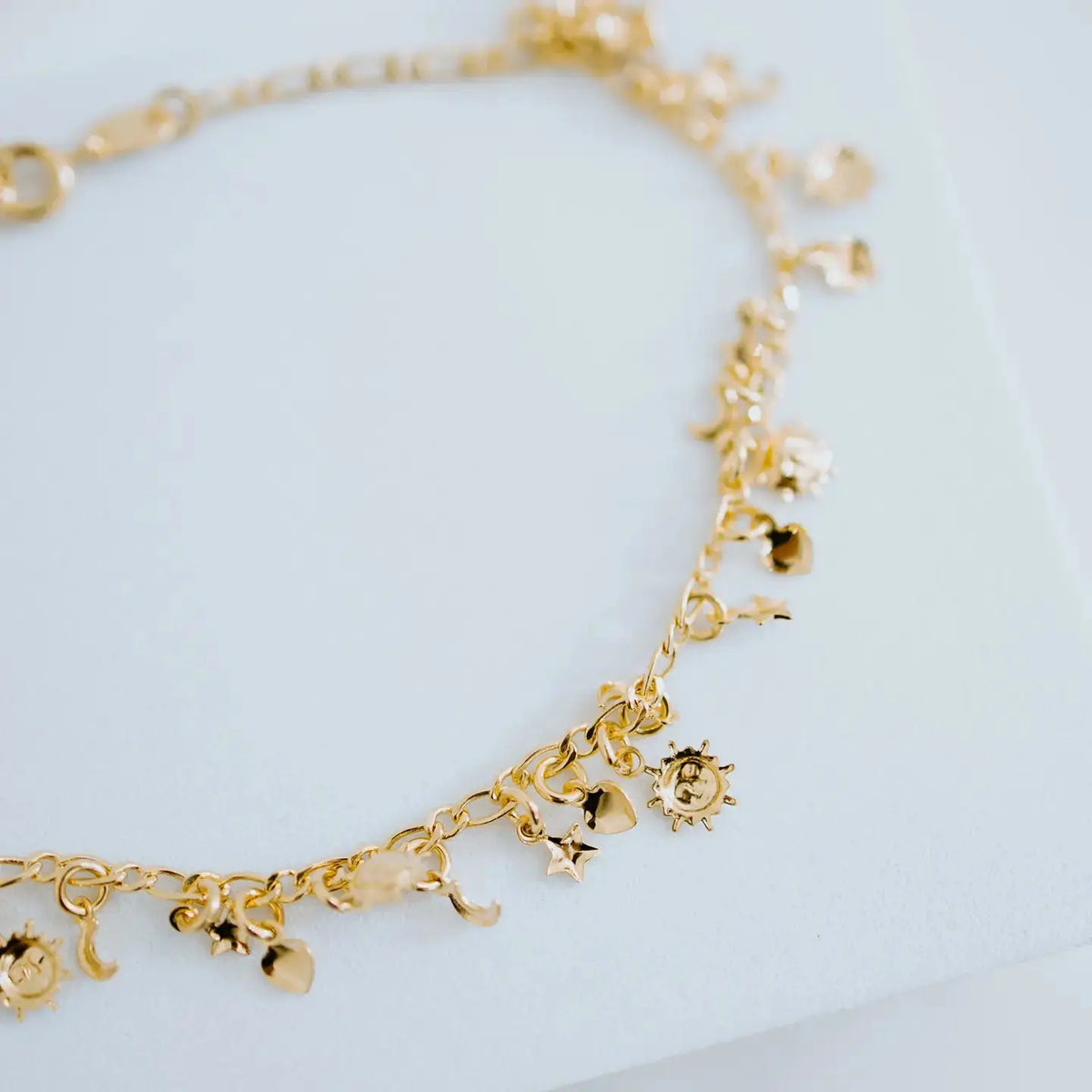Gold charm anklet with delicate chain and small decorative charms, stylish jewelry by Sydney Rose Co.