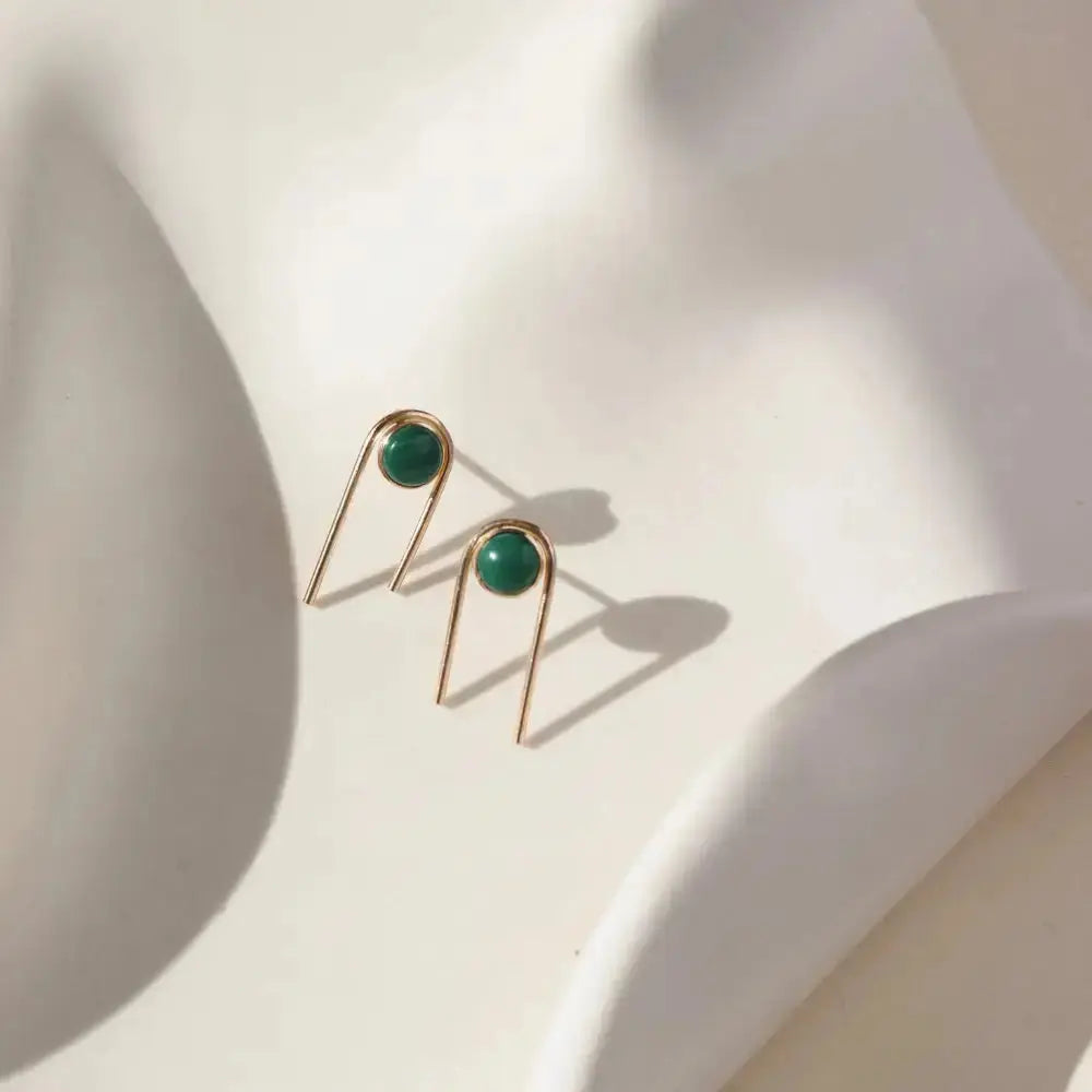 Gold arc stud earrings featuring vibrant green Malachite stones by Token Jewelry, showcasing elegant jewelry design.