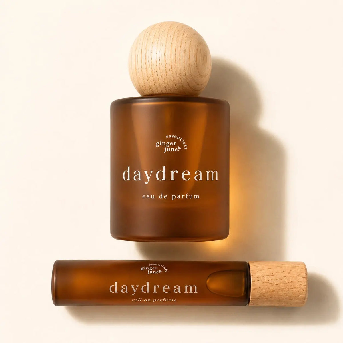 Daydream perfume by Ginger June featuring a sleek glass bottle with a soft pink floral design and a silver cap.