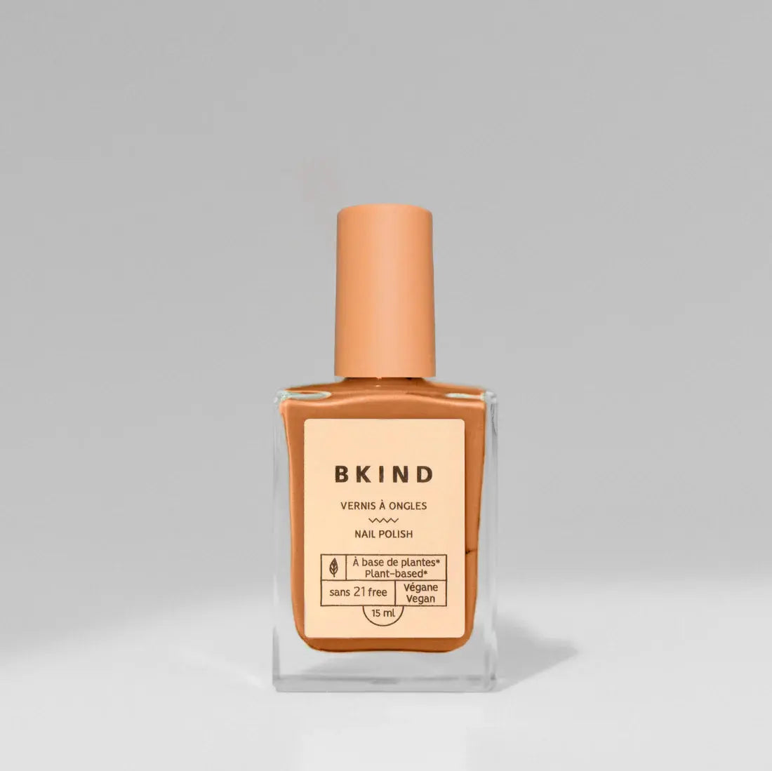 BKIND Val-d’Or nail polish bottle with glossy finish and vibrant color, displayed on a neutral background.