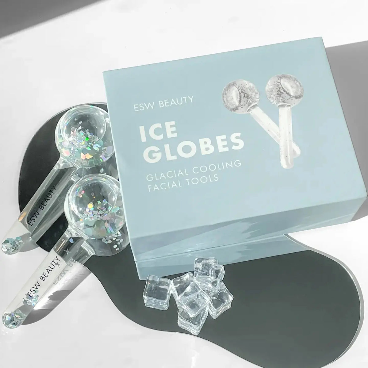 ESW Beauty Glacial Duo Ice Globes for skincare, shown cooling and massaging the face in a natural skincare routine.