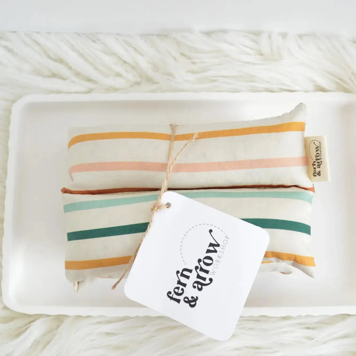 Fern and Arrow aroma therapy neck wrap with striped fabric, designed for personal relaxation and soothing heat therapy.