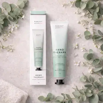 Midnight Paloma Hand Therapy with eucalyptus and peppermint, shown in a sleek jar with fresh eucalyptus and peppermint leaves.