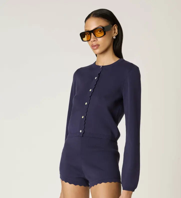 NIA Roxie scallop detail cardigan in extra small, soft knit fabric with scalloped edges, styled on a model.