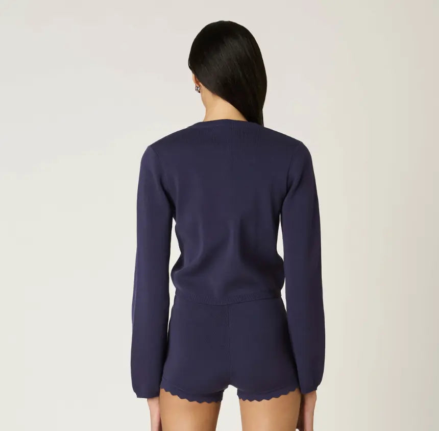 NIA Roxie scallop detail cardigan in extra small, soft knit fabric with delicate scalloped edges, worn by a model.