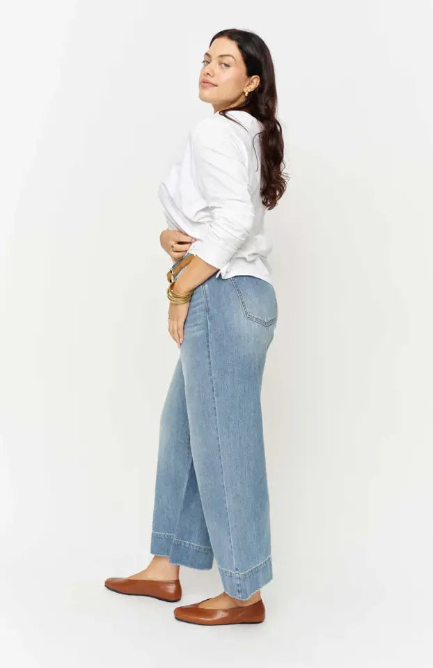 Olive green Dakota High Rise apparel pants by Oliver Logan displayed on a hanger with a focus on the waistband and fabric texture.
