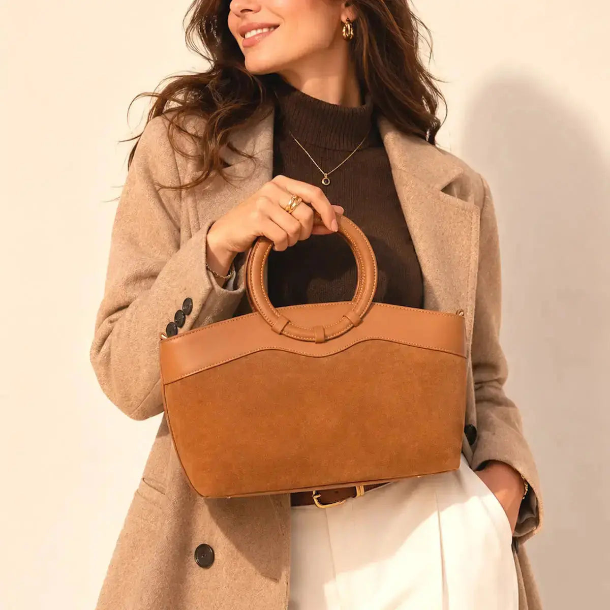 Suie Valentini Siena suede handbag featuring a sleek design, top handle, and elegant craftsmanship on a neutral background.