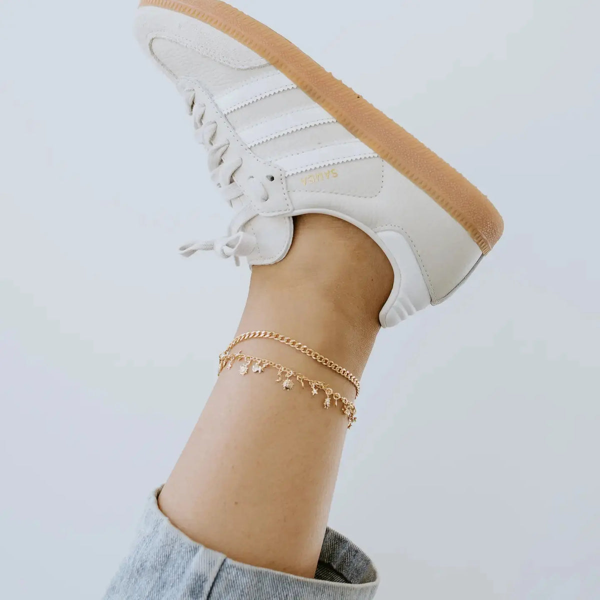 Gold charm anklet from Sydney Rose Co. featuring delicate chain and small decorative charms on a neutral background.