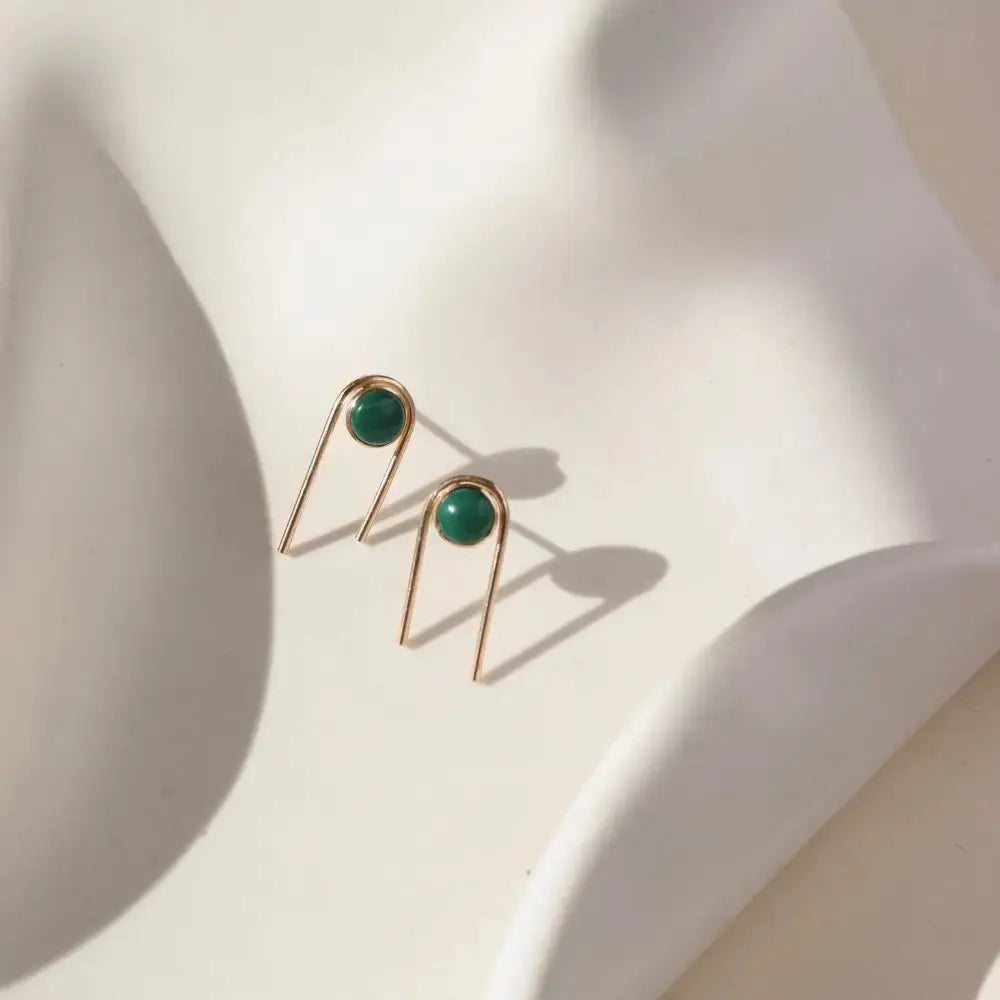 Gold arc stud earrings featuring vibrant green Malachite stones by Token Jewelry, showcasing elegant jewelry design.