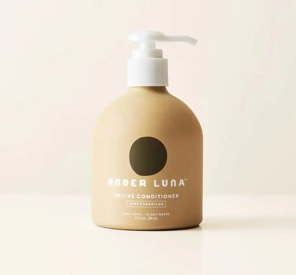 Under Luna Revive Conditioner for hair, 2 oz bottle, with creamy texture and natural ingredients visible in the image.