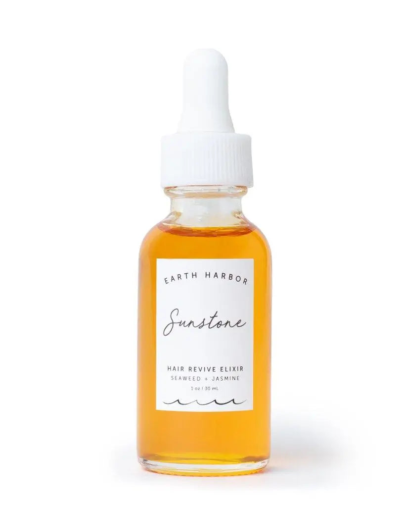 Earth Harbor Sunstone Hair Revive Elixir in a glass bottle, natural haircare product for revitalizing and nourishing hair.