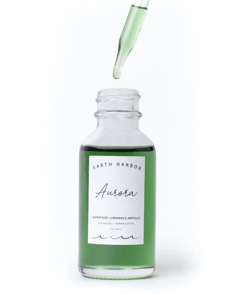 Earth Harbor Aurora Superfood Clarity Concentrate skincare serum in a glass bottle with a dropper applicator.