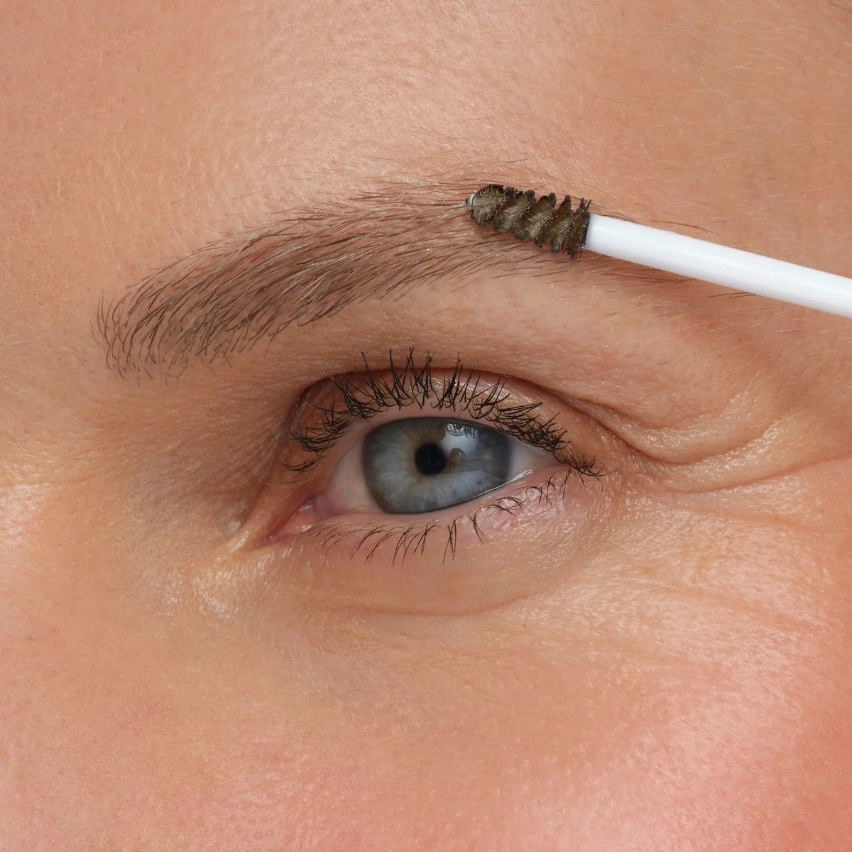 Jane Iredale PureBrow® brow gel in ash blonde, showcasing the clear, tinted brow gel with a brush applicator for natural-looking brows.