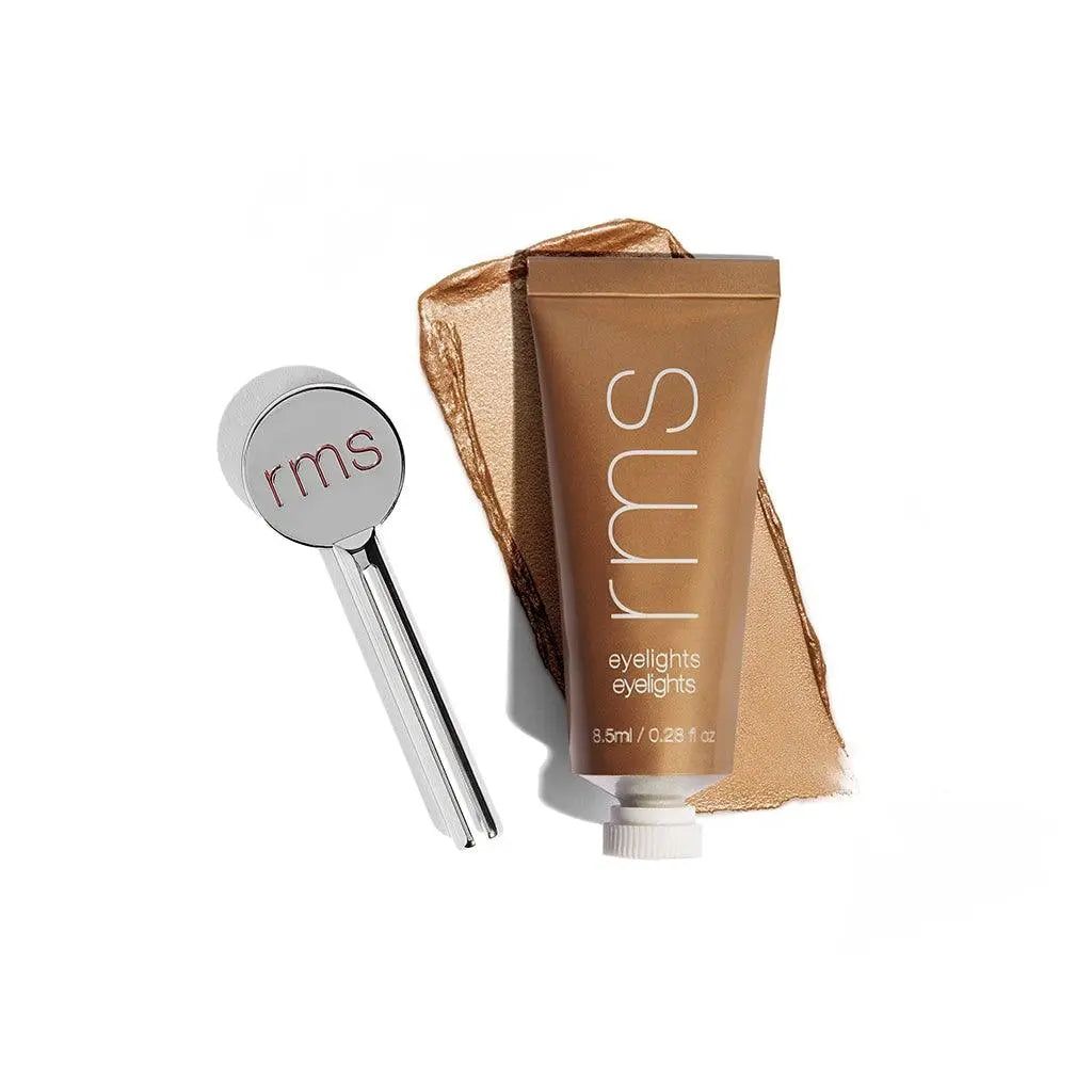 RMS Beauty Eyelights Cream Eyeshadow in Flare showing a swatch of shimmering peachy-orange eye makeup on skin